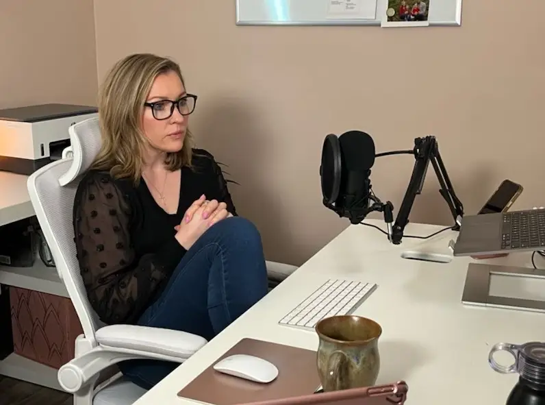 Jennifer Sakowski sits at her desk in her office working on running her business